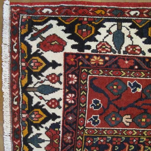 فرش دستباف بلداجي بختيار طرح خشتي سایز ميانه رنگ زمینه الوان رنگ حاشیه كرم کد ۳۹۲۹۹