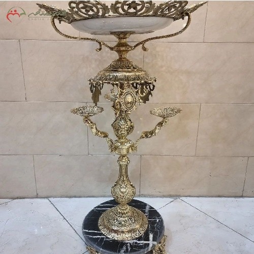 میوه خوری کنار سالنی با بدنه ی تمام برنزی و رنگ طلایی طرح دار، زیبا و با کیفیت