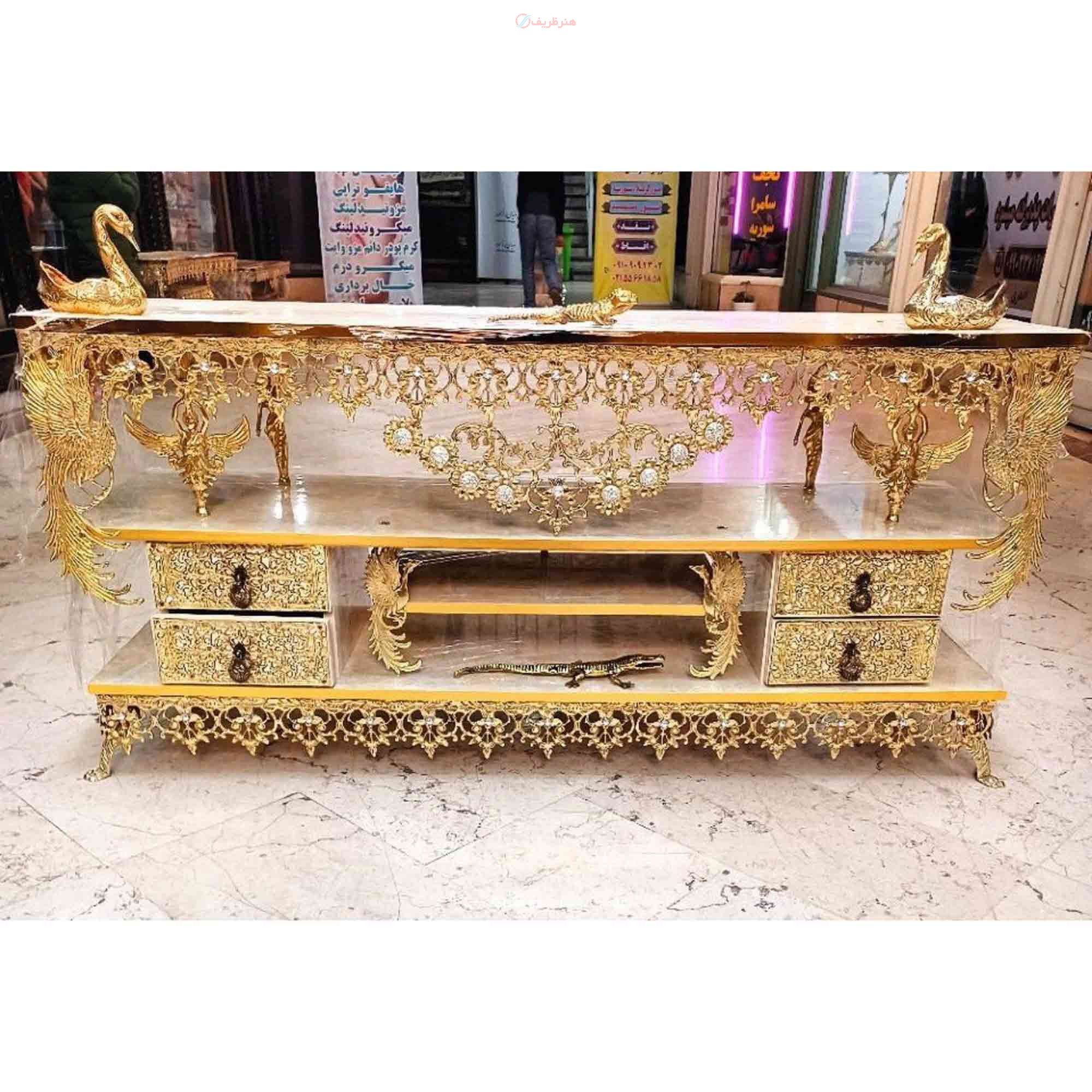 میز تلویزیون برنزی در طرح گل آفتابگردان دارای چهار کشو، طاووس دار