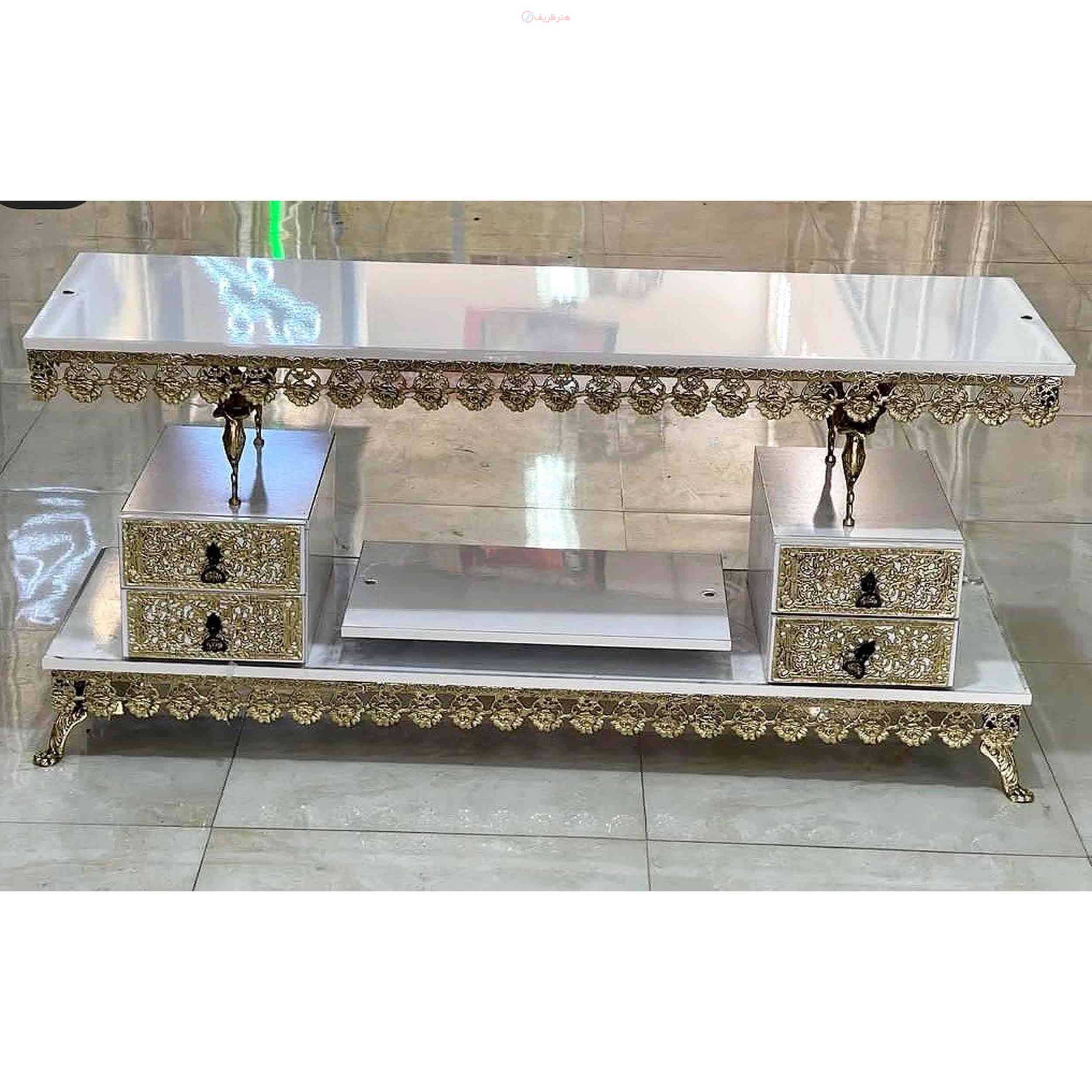 میز تلویزیون برنزی رویه ی سفید طول 120، دو طبقه دارای  چهار کشو